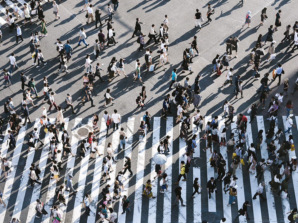 crowd of people walking across a crosswalk