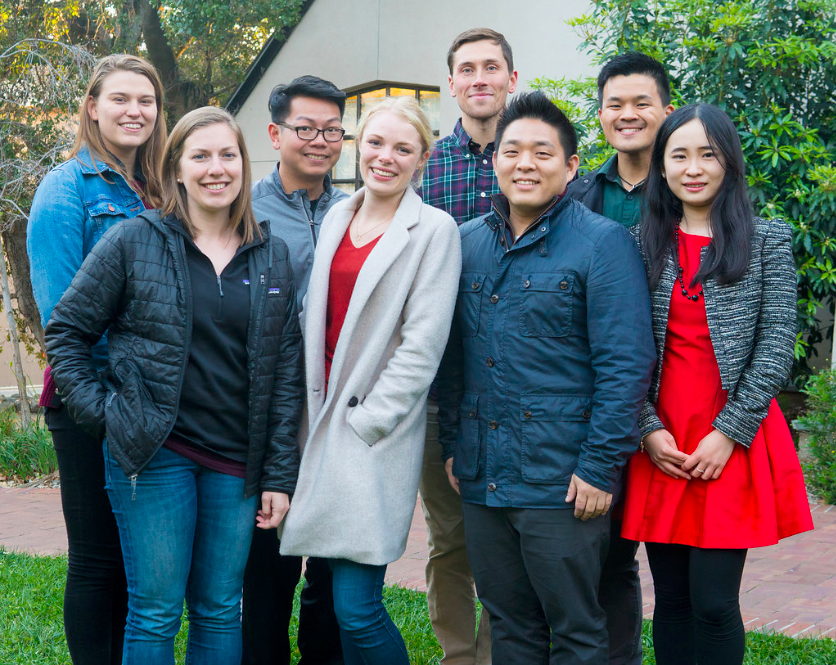 Eight Goldman students stand in front of the Goldman School, smiling for the camera.